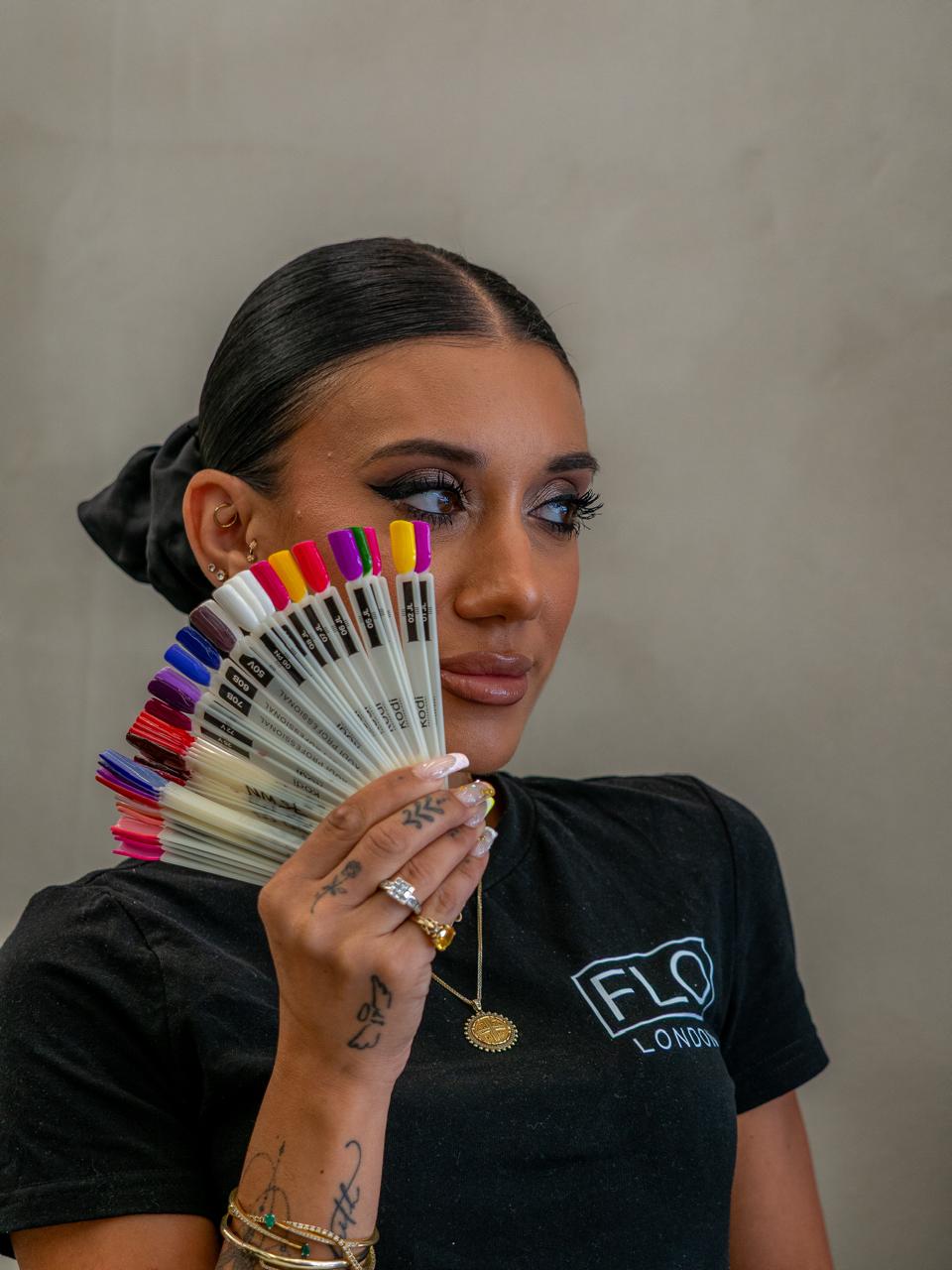 Flo London nail artist holding a fan of gel colour swatches